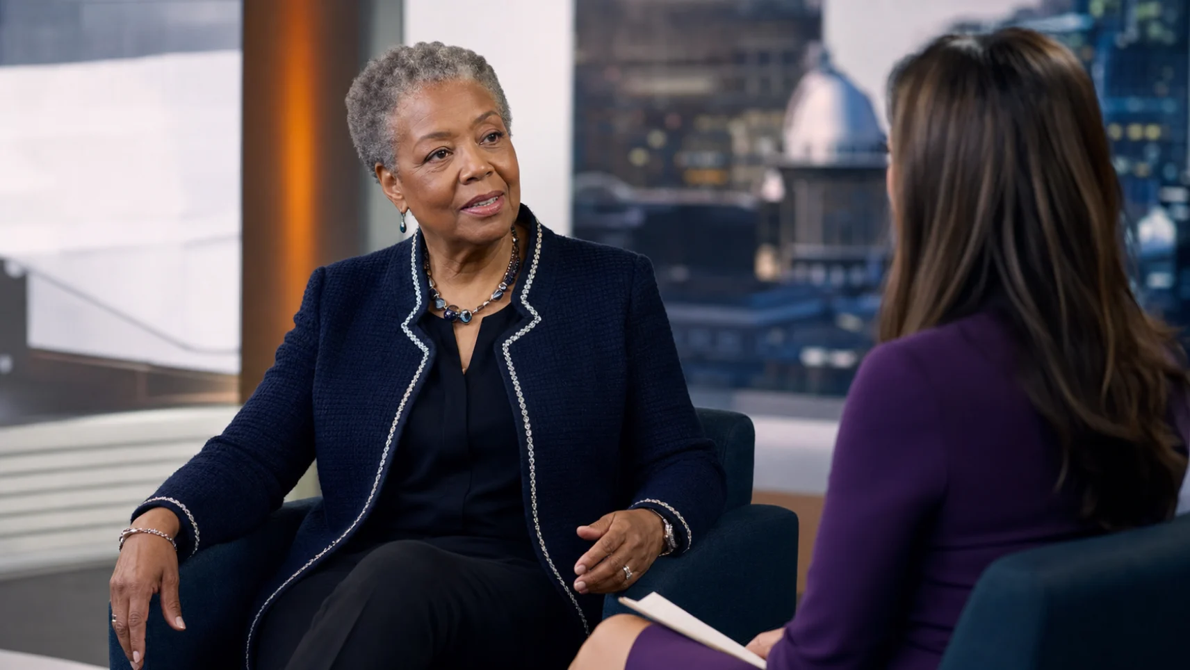 A senior executive being interviewed on camera in a television studio