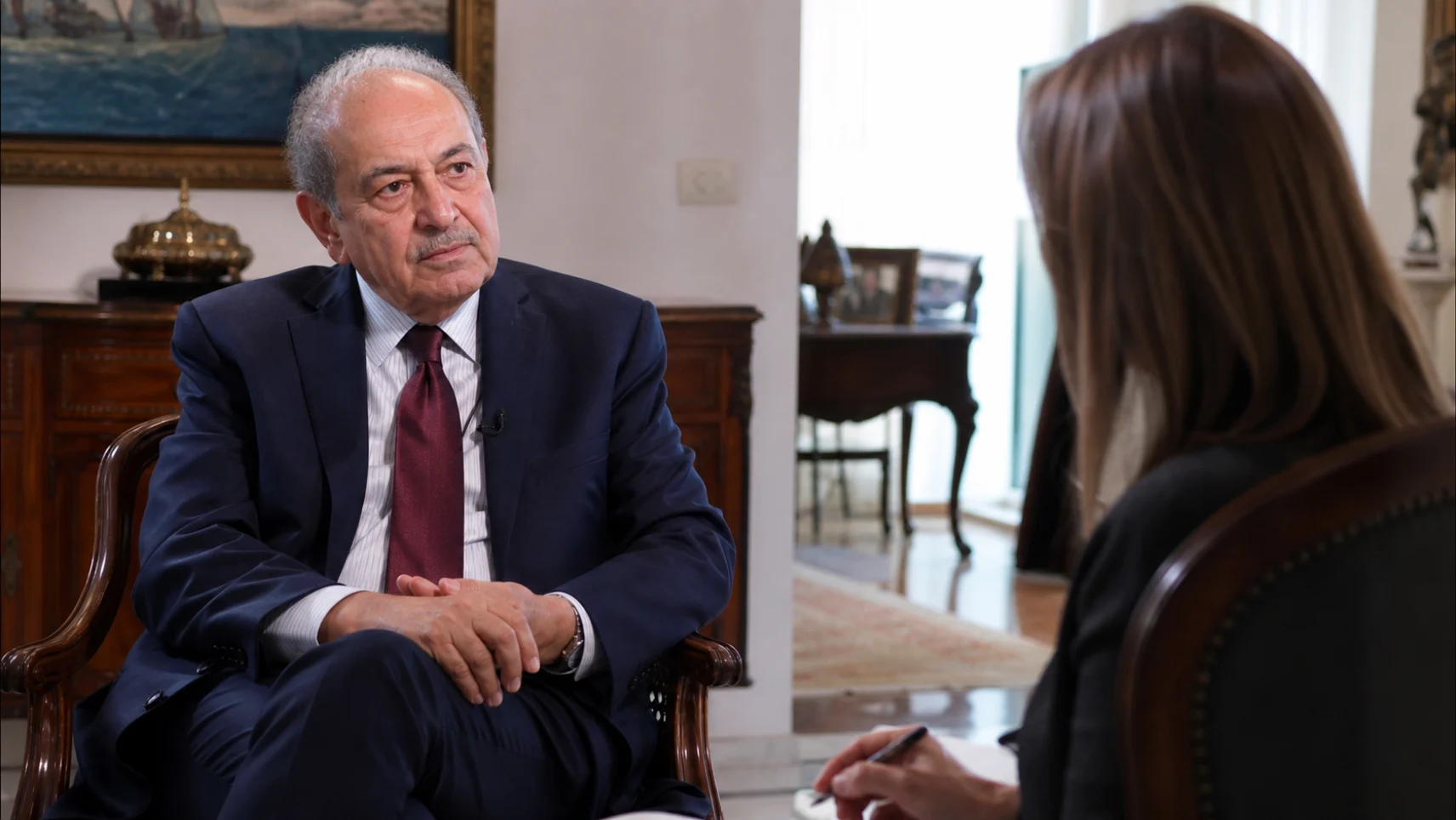 An executive listening to a reporter's question during a seated interview