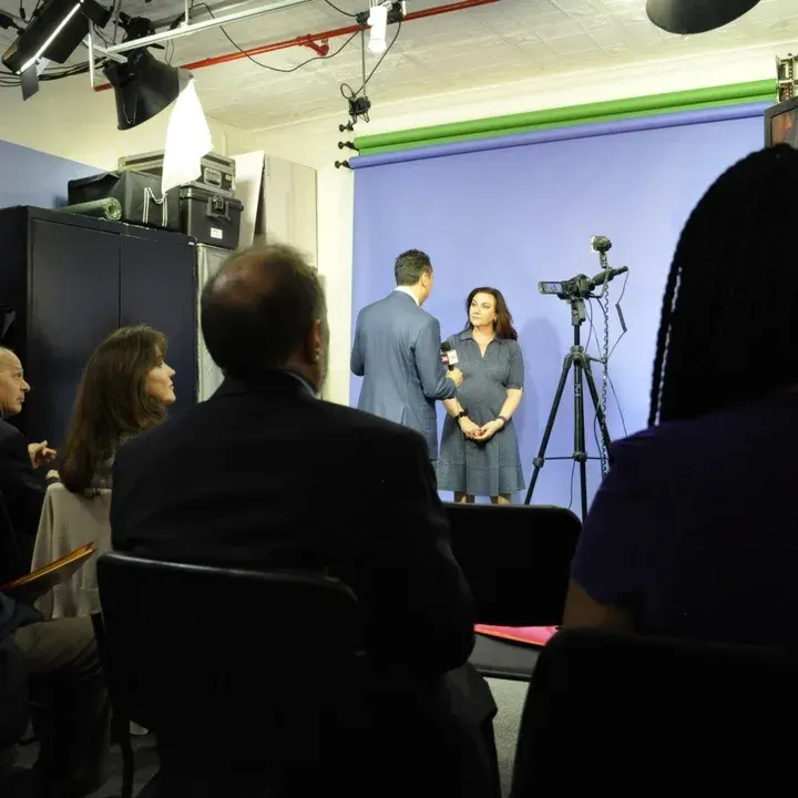 Success in Media NYC learning center at 295 Madison Avenue, New York: a client is interviewed in front of a backdrop while others watch